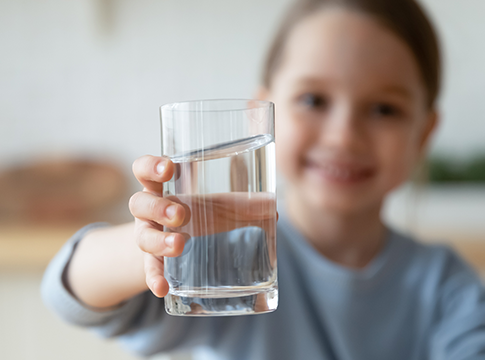 Child holding up a glass of tap water