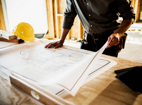 Contractor leaning on a table looking at blueprints