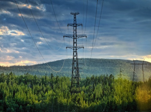 Transmission lines against a sunset landscape