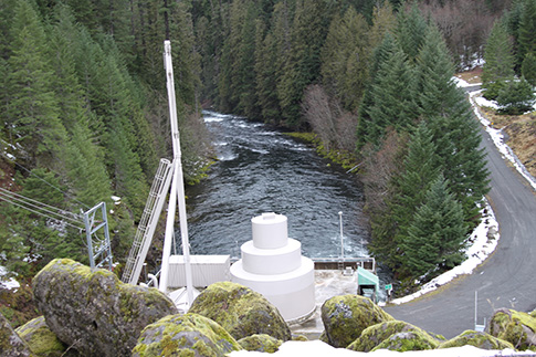 Photo from the top of Trail Bridge Dam with generator in foreground and McKenzie River aft.
