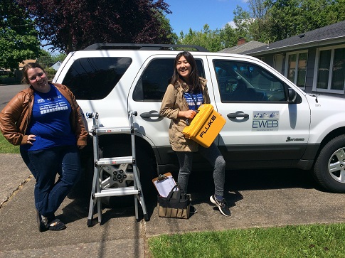 Picture of two smiling interns standing by an EWEB truck