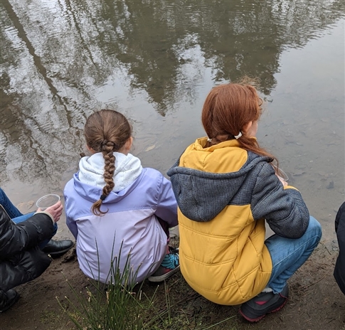 Children kneeling by canal