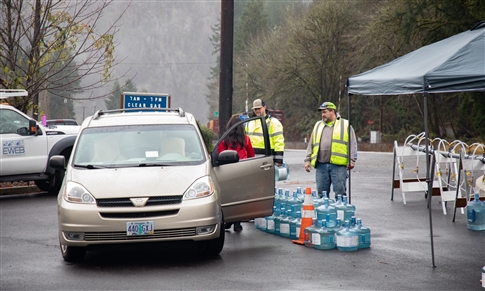 EWEB crews assist woman putting water in car in Mapleton