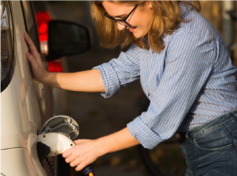 Woman charging electric vehicle