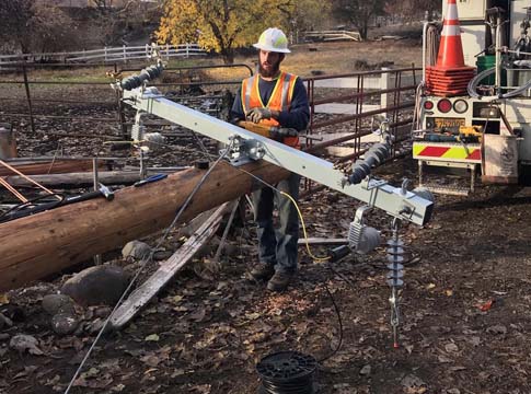 EWEB line technician attaches a new crossarm on a power pole