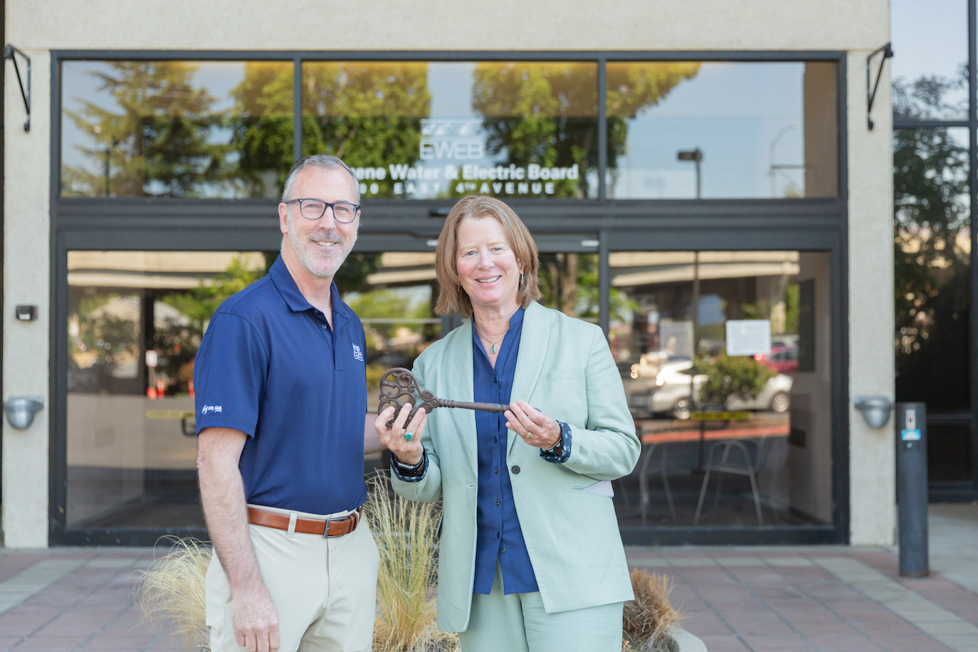 EWEB General Manager Frank Lawson and Eugene City Manager Sarah Medary hand over the keys to EWEB's former riverfront headquarters buildings.
