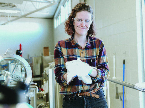 Woman worker in flannel shirt and goggles