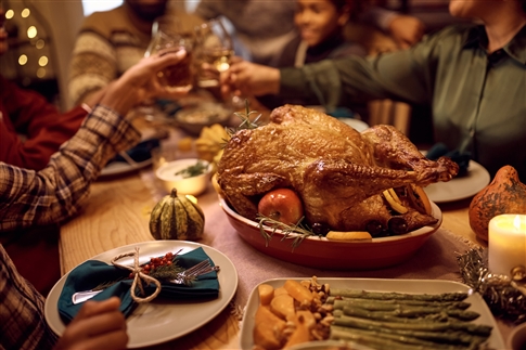 Family together around a Thanksgiving food table