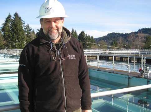Hayden Bridge Filrattion employee smiling in front of plant