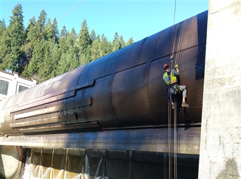 man in hard hat and safety vest inspecting leaburg dam rollgate