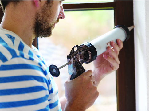 Man caulking a window