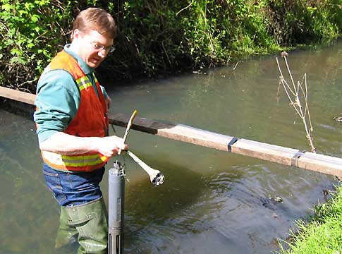 Picture of staff sampling water in waders