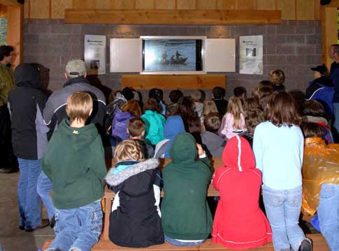 Classroom of students watching a video in the Lloyd Knox Park shelter.