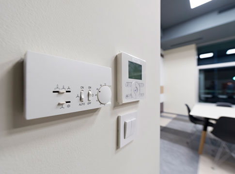 Programmable thermostat on an office wall.