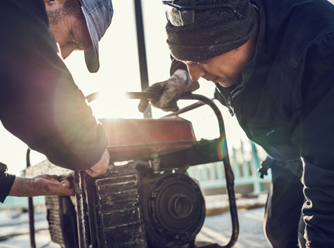 2 men working on a generator