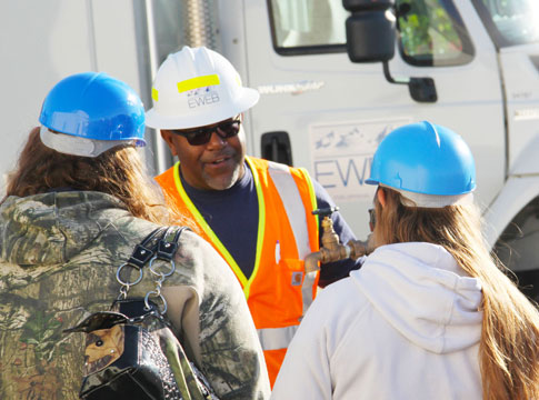 Utility career fair with one EWEB employee and two students talking wirh him