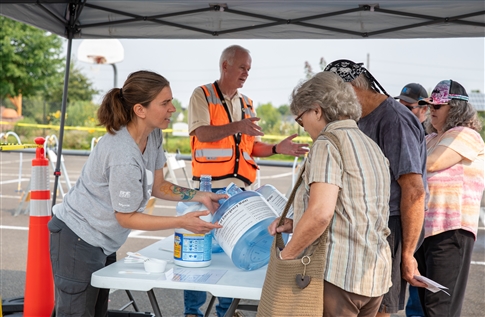 Staff help residents learn how to disinfect well water in a container to make it safe to drink