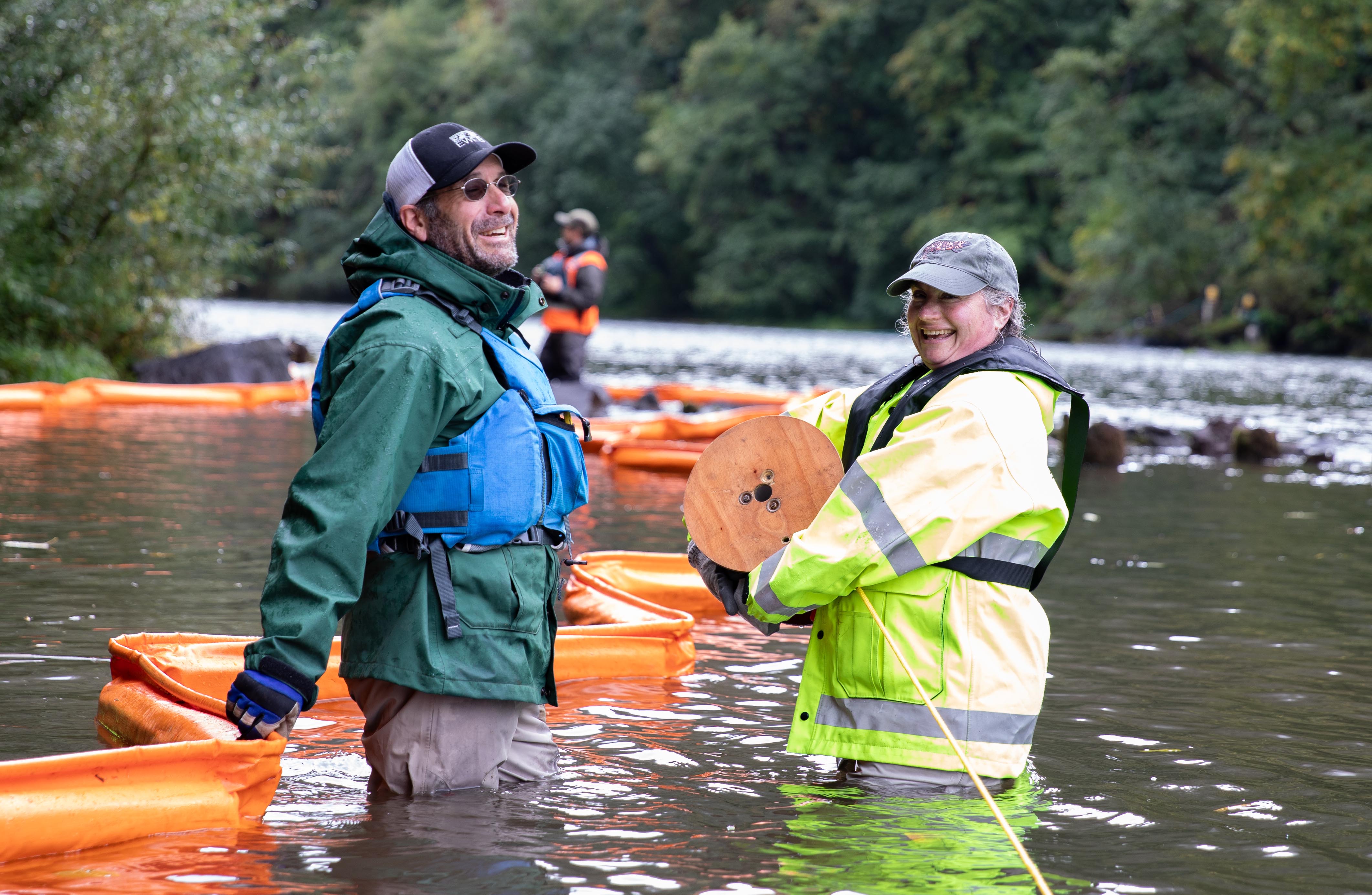 EWEB employees deploy containment boom on the river.