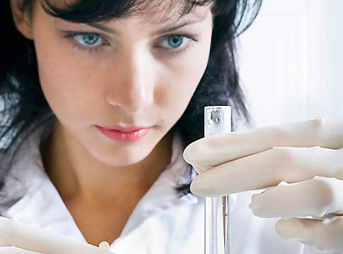 Scientist looking at a test tube filled with water.