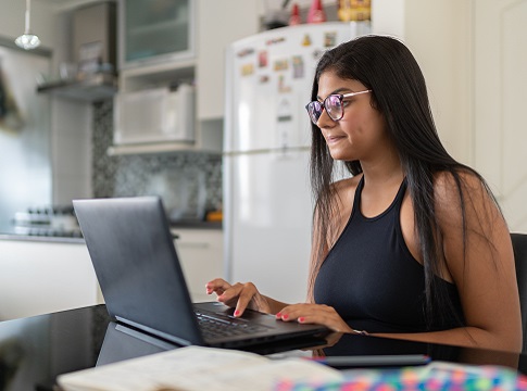 Young woman with glasses working on laptop computer
