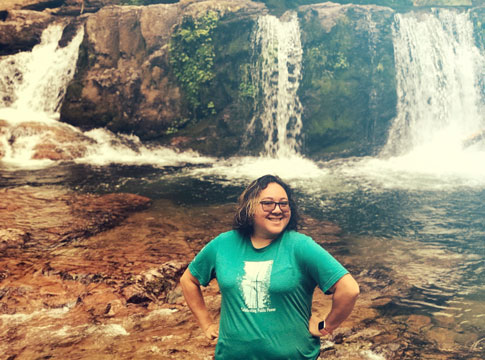 Woman standing in front of a small waterfall