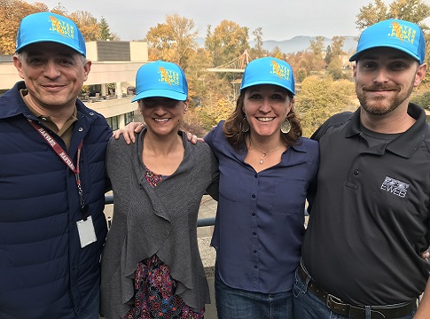 Four EWEB staff posing with matching caps