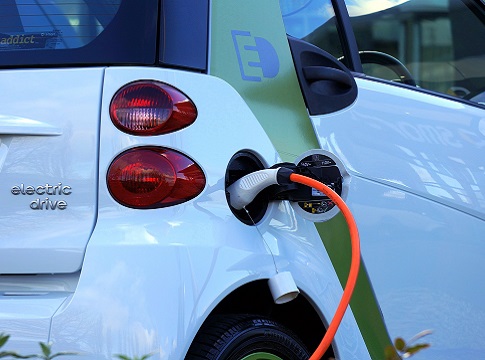 An electric car plugged in with a charging cord