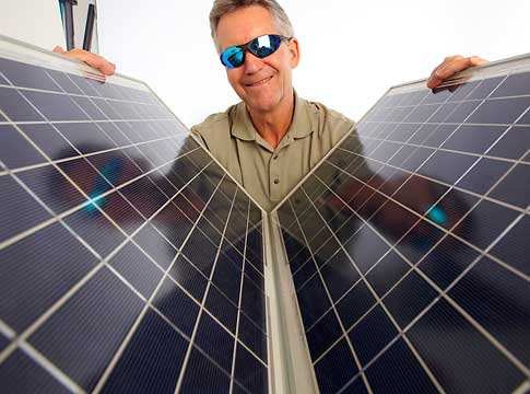 MAn holding solar panels and wearing sunglasses