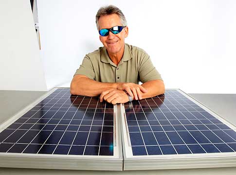 Man wearing sunglasses with solar panel on a table.