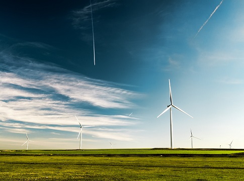 Windmills in a green field with blue sky