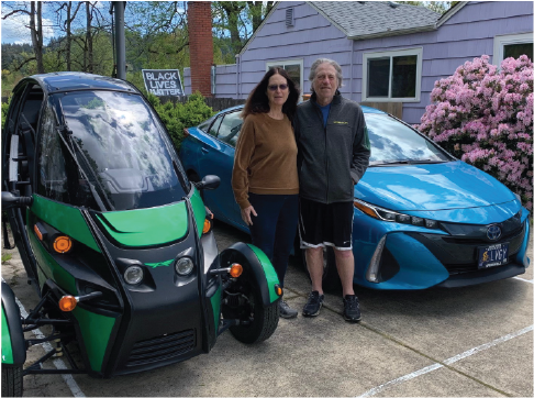 Green Arcimoto & blue Prius hybrid by owners Bill & Pearl.