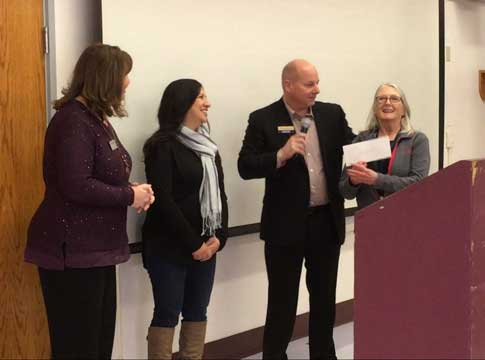 Customer Care program supervisor, Kathy Grey, receiving a check from SPIN board members