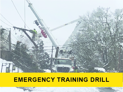 Picture of snowstorm and line crews working with a "Emergency Training Drill" banner
