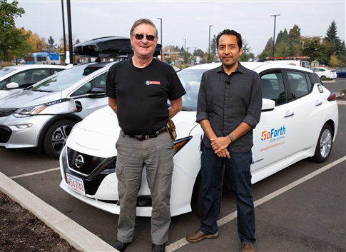 Terry McDonald, executive director of St. Vincent de Paul of Lane County, and Juan Serpa Munoz, a business line manager of EWEB, stand beside one of the EVS in EWEB's ne car sharing program, GoForth CarShare