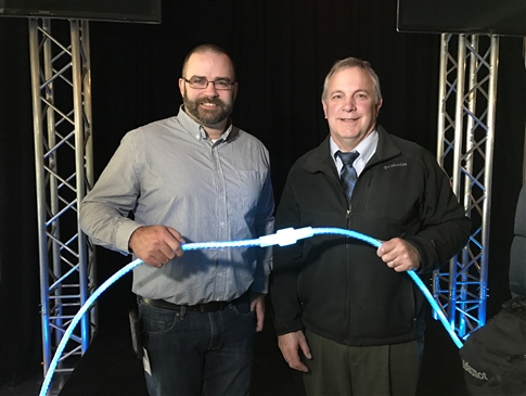 EWEB staff hold a glowing strand of fiber optic cable at the Fiber Lighting Ceremony