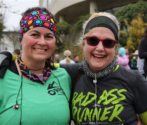 Two smiling women who are running in the Run to Stay Warm
